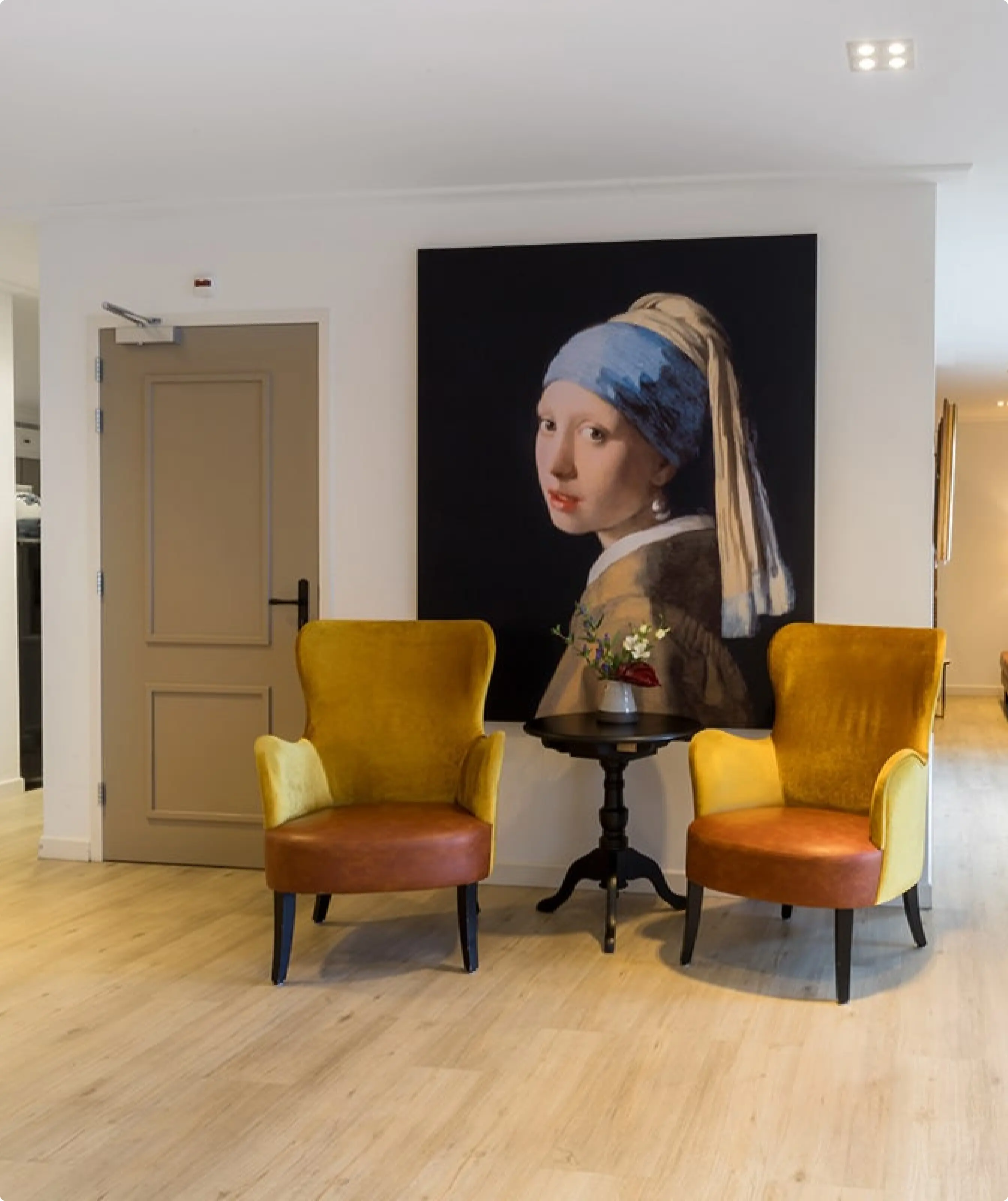 Modern room with two orange chairs and classic image at the background 